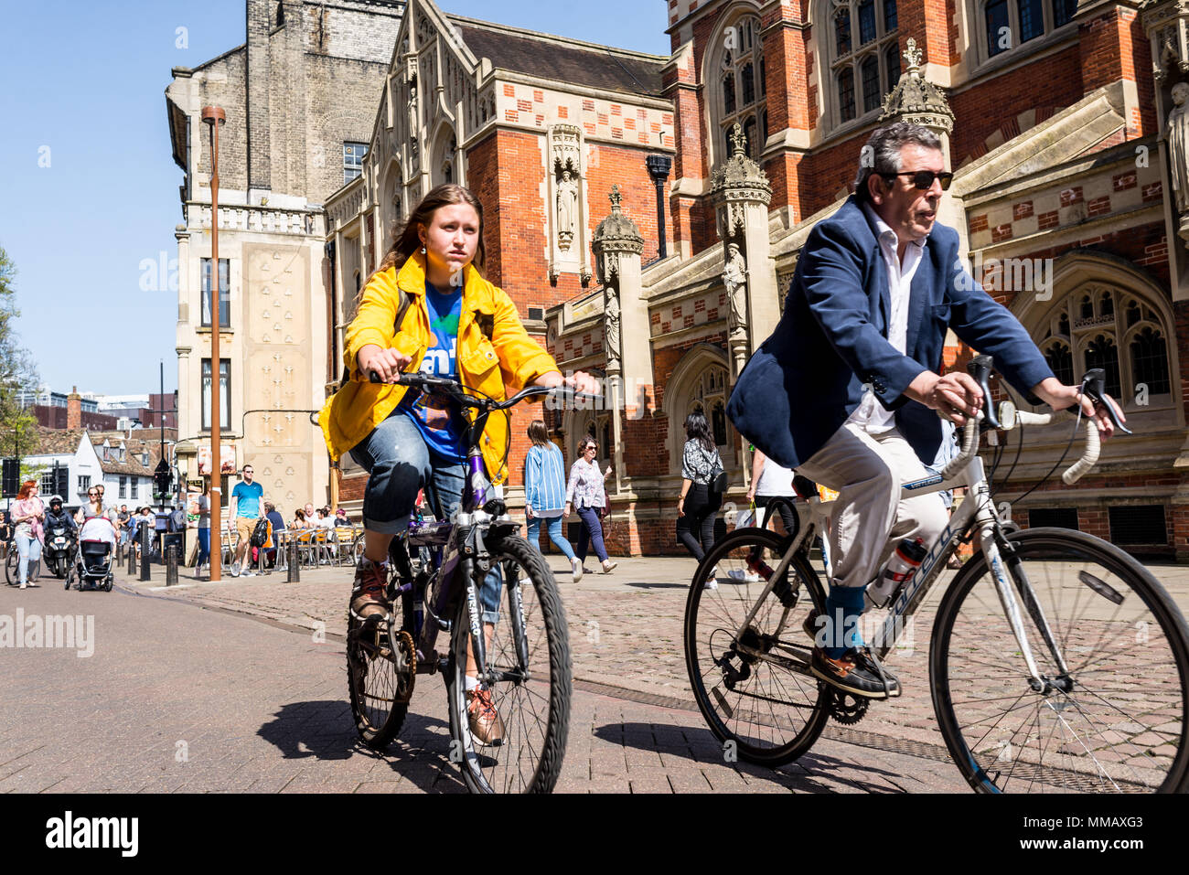 Cambridge, Regno Unito - Aprile 2018. Persone in bicicletta accanto alla vecchia scuola di divinità in St Johns street, centro di Cambridge city centre Foto Stock