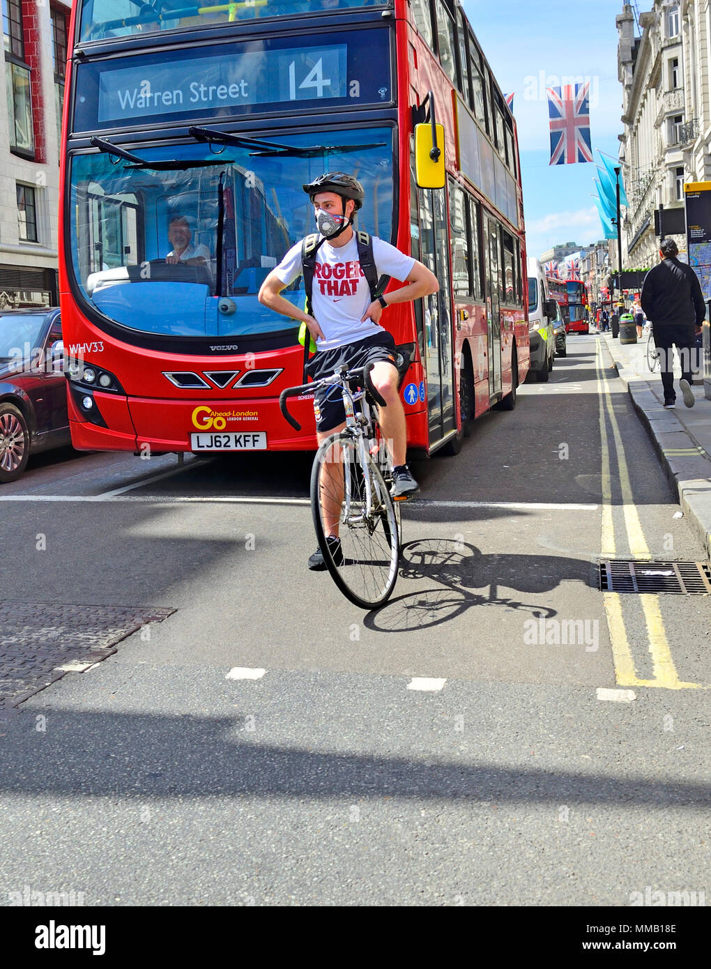 Londra, Inghilterra, Regno Unito. Ciclista indossa una maschera facciale nel centro di Londra Foto Stock