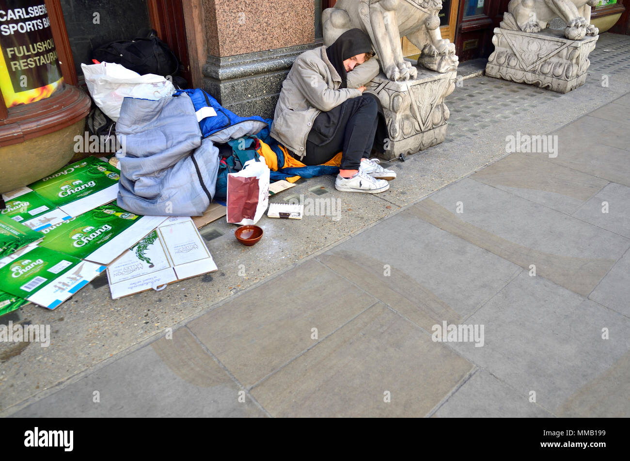 Londra, Inghilterra, Regno Unito. Senzatetto uomo dorme in modo irregolare a Shaftesbury Avenue Foto Stock