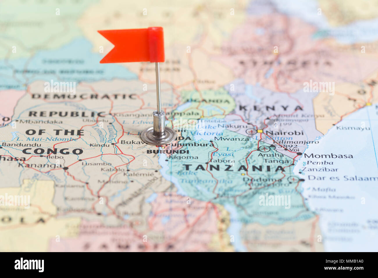 Piccola bandiera rossa segna il paese africano del Burundi su una mappa del mondo. Foto Stock