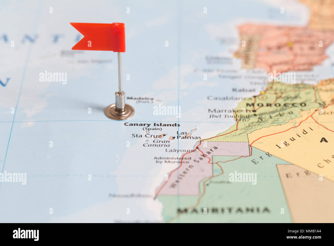 Piccola bandiera rossa la marcatura delle Isole Canarie su una mappa del mondo. Foto Stock