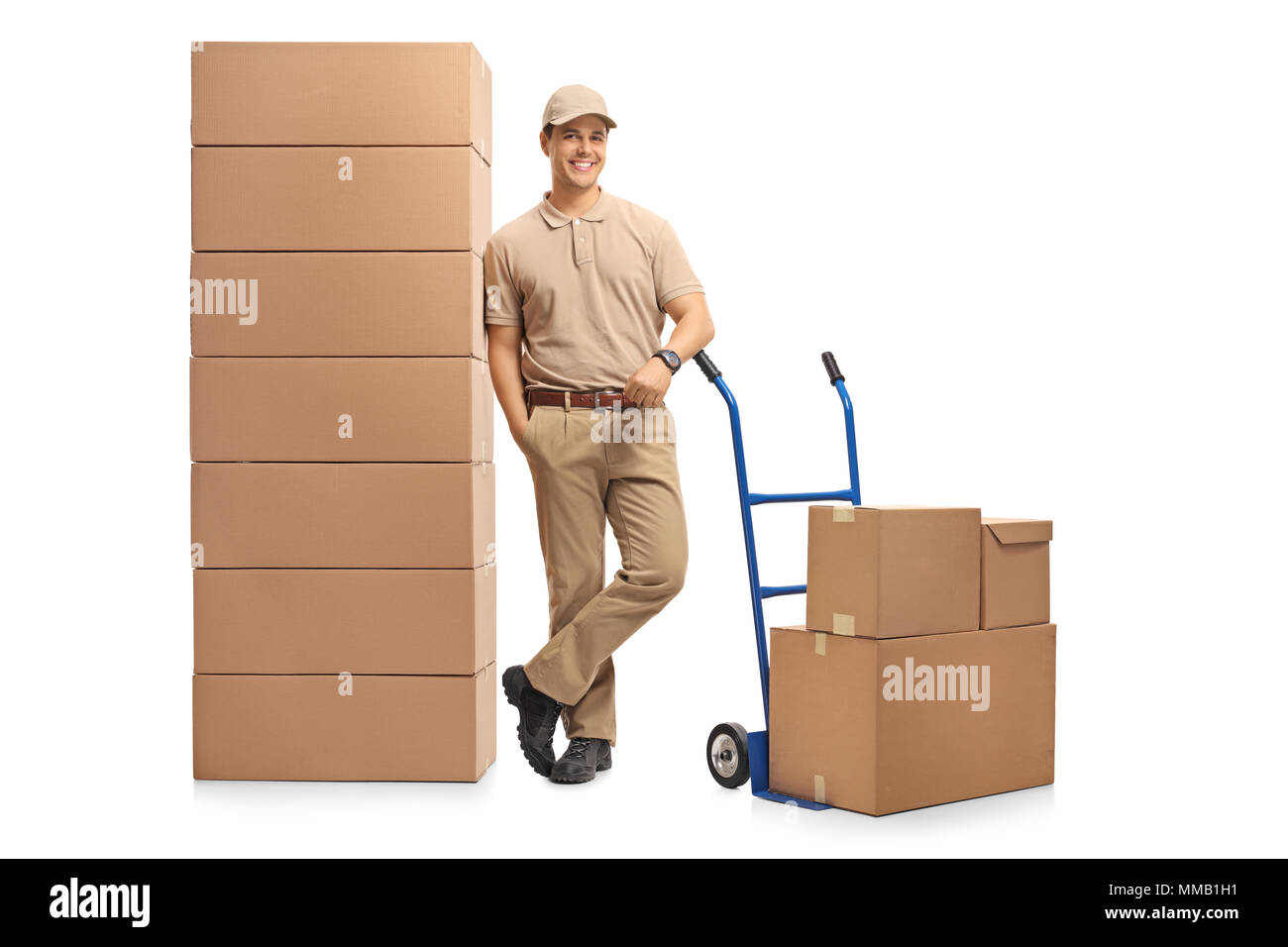 A piena lunghezza Ritratto di un uomo di consegna con un carrello elevatore a mano appoggiata su una pila di scatole isolate su sfondo bianco Foto Stock