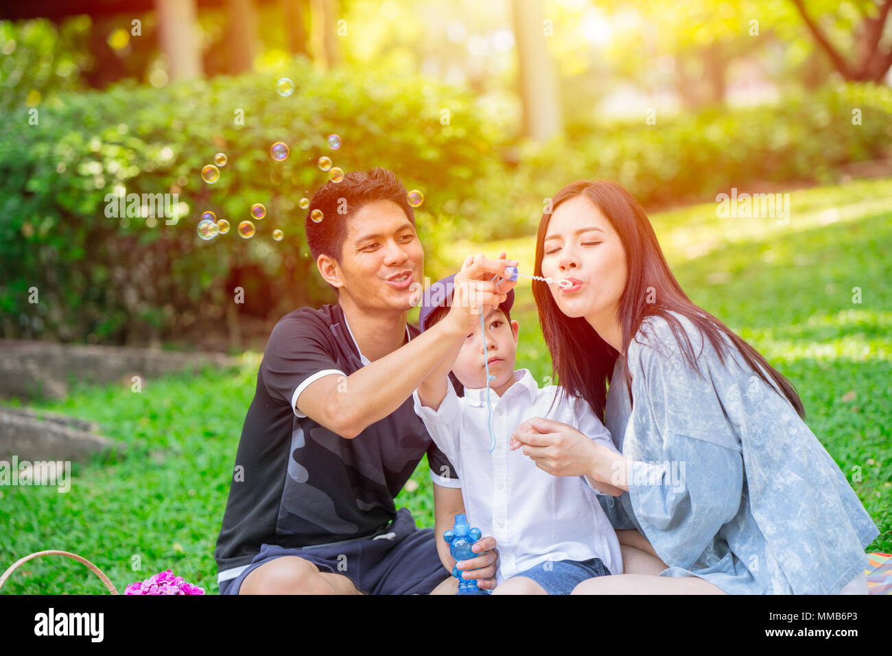 Asian teen famiglia un bambino felice vacanza momento picnic nel parco. Riproduzione di bolla. Foto Stock