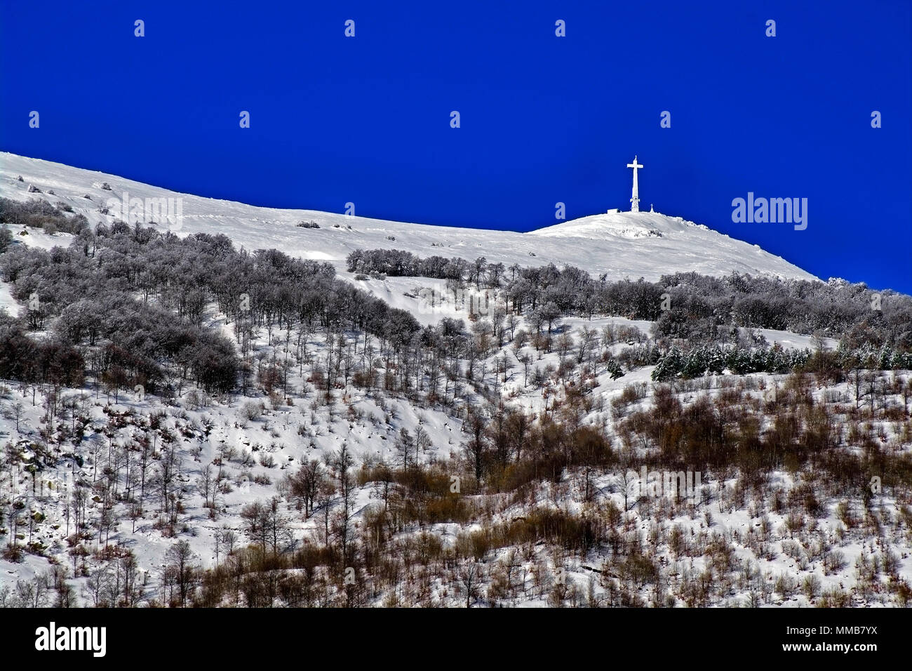 Vista della cima del monte Mindino, con la sua elevata (25 m + 2 di base in cemento) croce nella neve. Alpi marittime,in provincia di Cuneo, Piemonte, Italia del Nord. Foto Stock