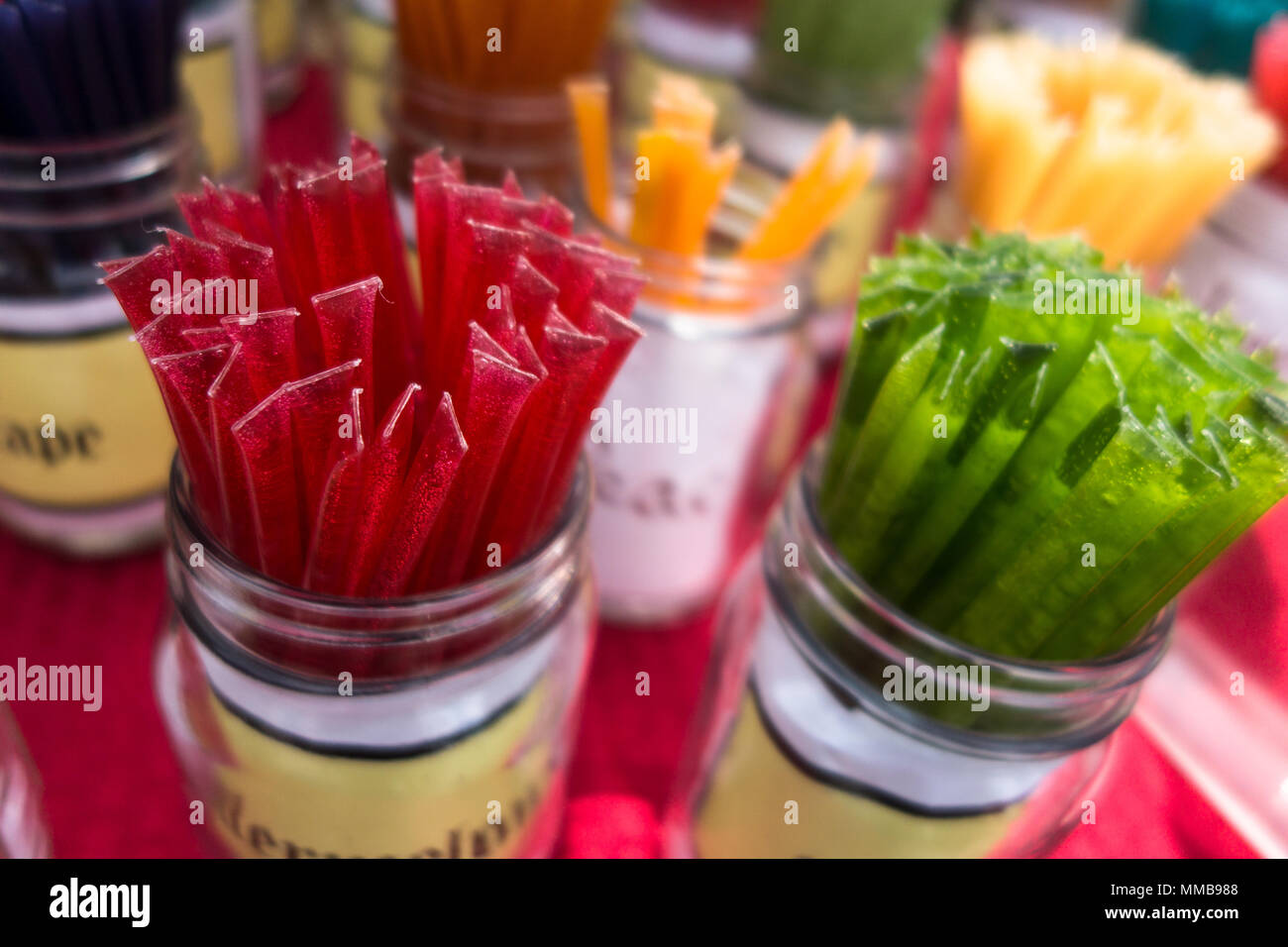 Caramelle colorate bastoni in vasi in vendita su un mercato degli agricoltori Foto Stock