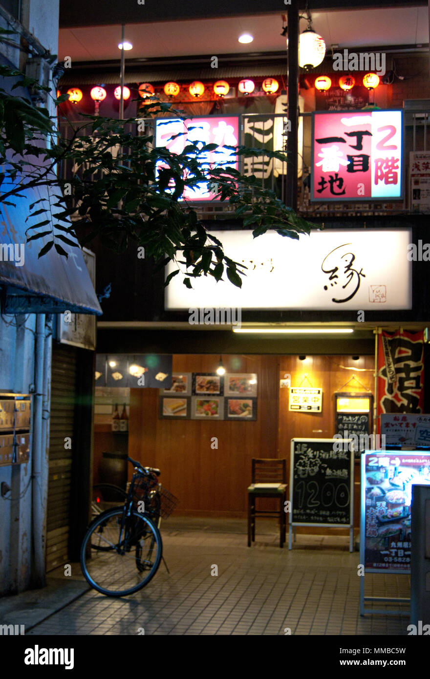 Tipico cortile giapponese con biciclette, neon e ristoranti, Tokyo, Giappone Foto Stock