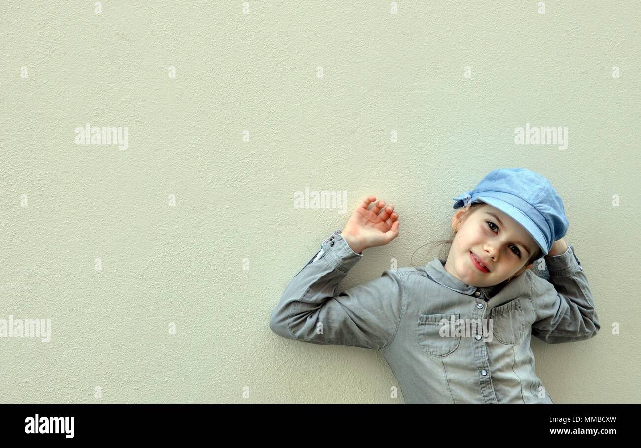 Bambino, ragazza, 8 anni, e giocando con le mani alzate, sorridente e sognante, vista anteriore verticale, spazio di copia Foto Stock