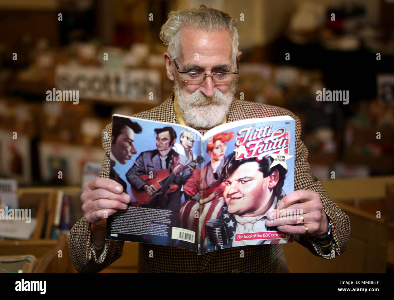 Autore, drammaturgo e artista John Byrne ha uno sguardo più da vicino a una rara edizione del suo gioco Tutti Frutti, all'aiuto Cristiana George Street prenota in vendita in Edinburgh. Foto Stock