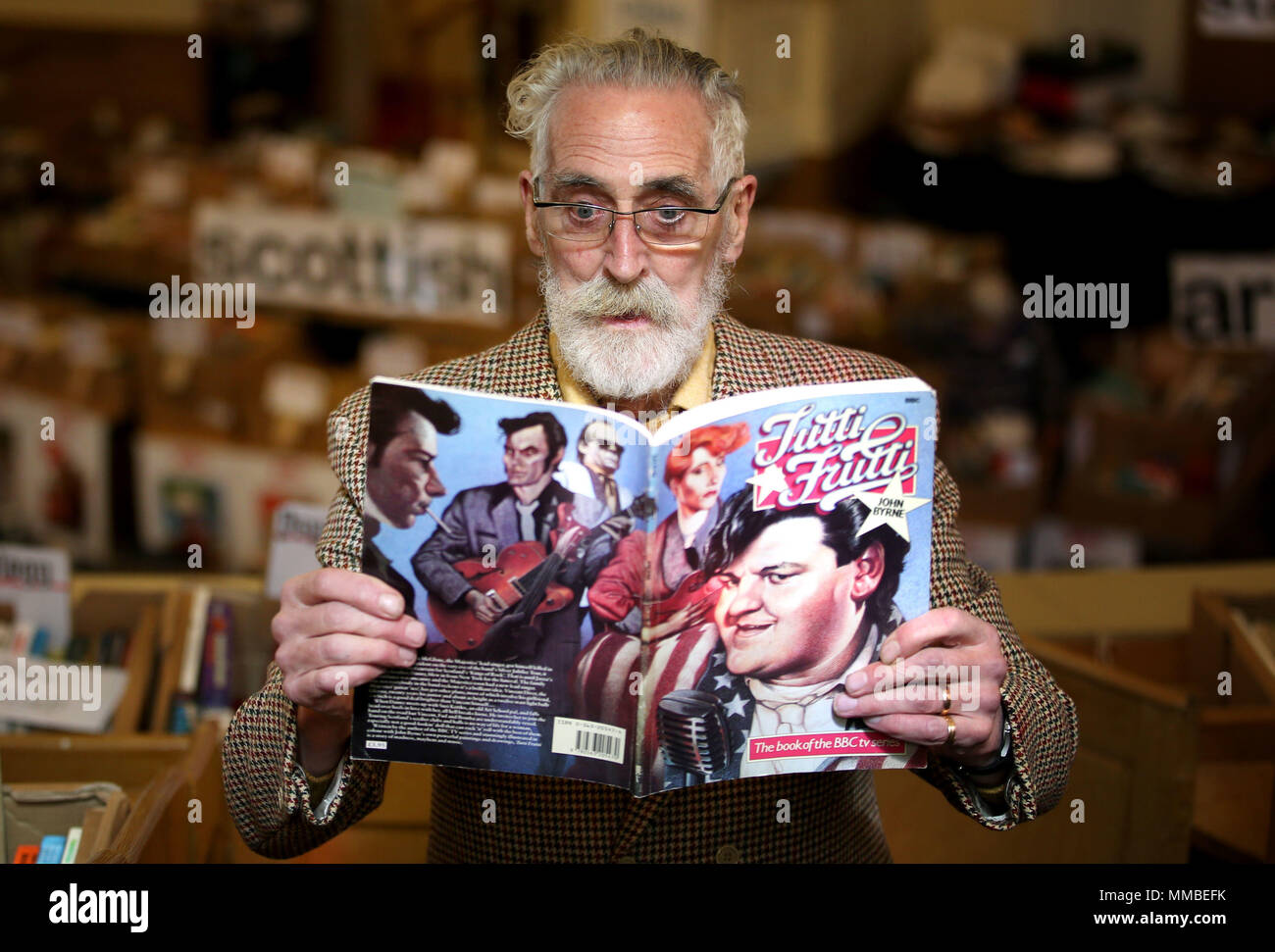 Autore, drammaturgo e artista John Byrne ha uno sguardo più da vicino a una rara edizione del suo gioco Tutti Frutti, all'aiuto Cristiana George Street prenota in vendita in Edinburgh. Foto Stock