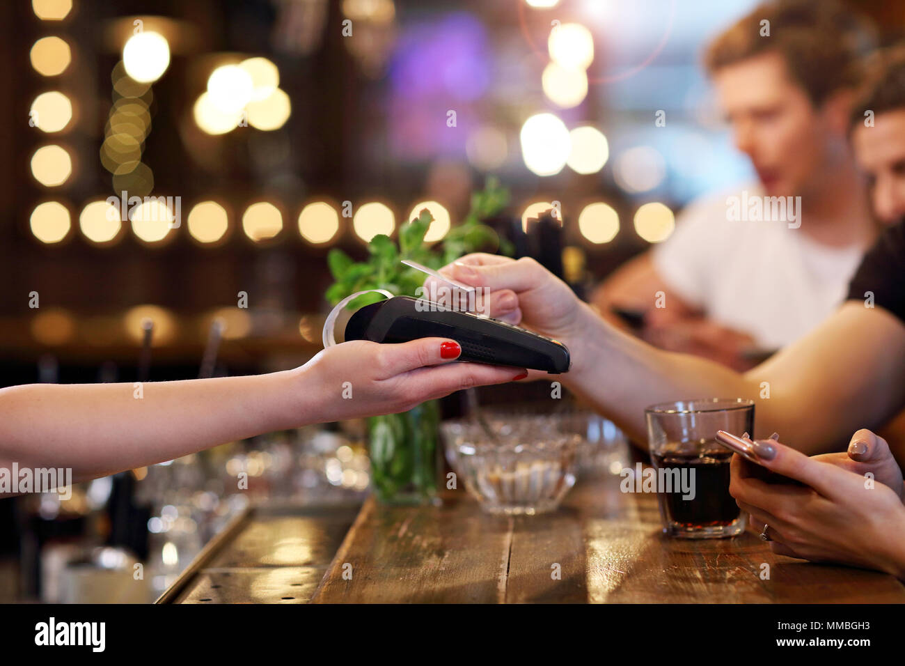 Gruppo di amici di pagare per il pasto in ristorante Foto Stock