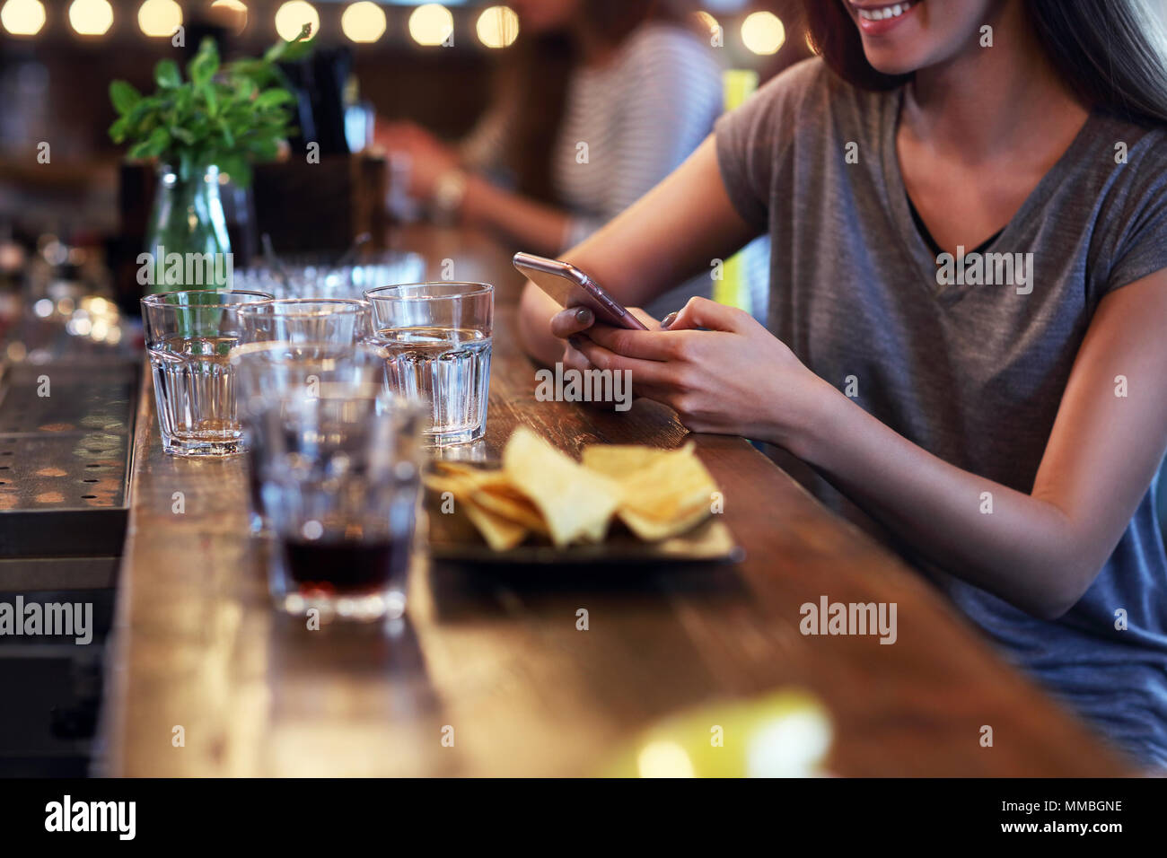 Sezione mediana della donna texting nel ristorante Foto Stock