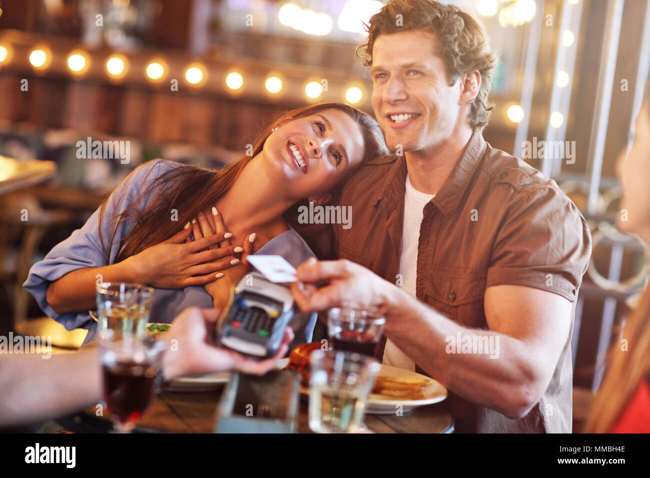 Carino coppia su una data presso il cafe pagando con carta di credito Foto Stock