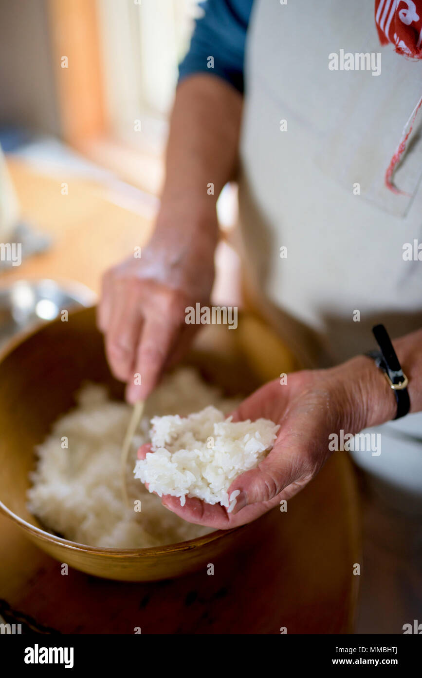 Close up della donna in piedi su un tavolo o in una cucina, rendendo il sushi. Foto Stock