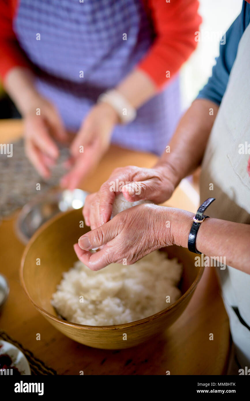 Close up della donna in piedi su un tavolo o in una cucina, rendendo il sushi. Foto Stock