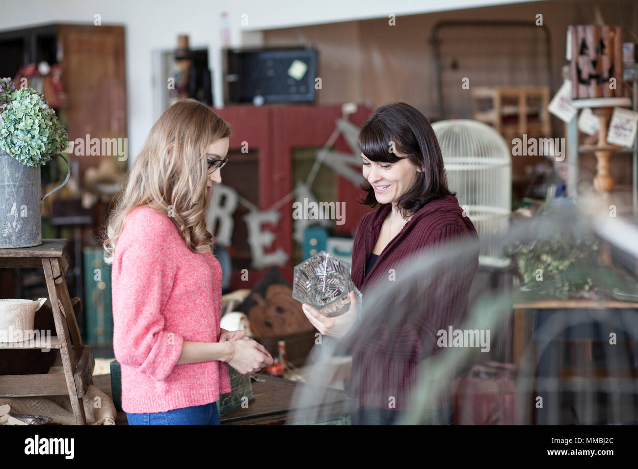Due donne caucasici shopping in un negozio di antiquariato Foto Stock