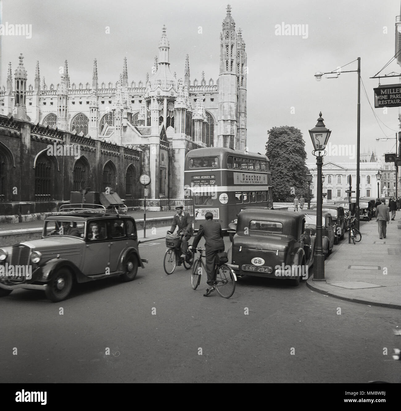 1950, centro storico di Oxford, auto e autobus dell'epoca, giro in bicicletta e vista sulla Cattedrale di Christ Church, uno degli edifici più antichi della città, con quasi 900 anni di età. Notate i bagagli tradizionali sul roofrack dell'auto. Foto Stock