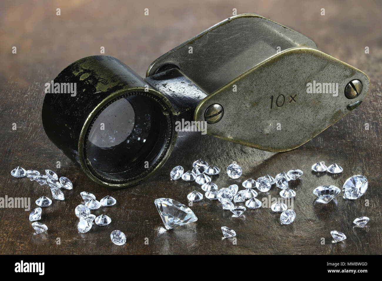 Diamanti taglio brillante con lente di ingrandimento pieghevole su sfondo di legno Foto Stock