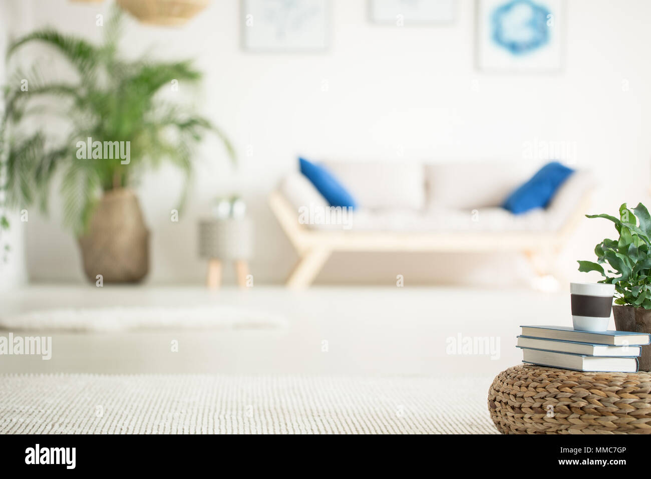 Elegante appartamento bianco con divano in legno, impianti e rattan pouf Foto Stock