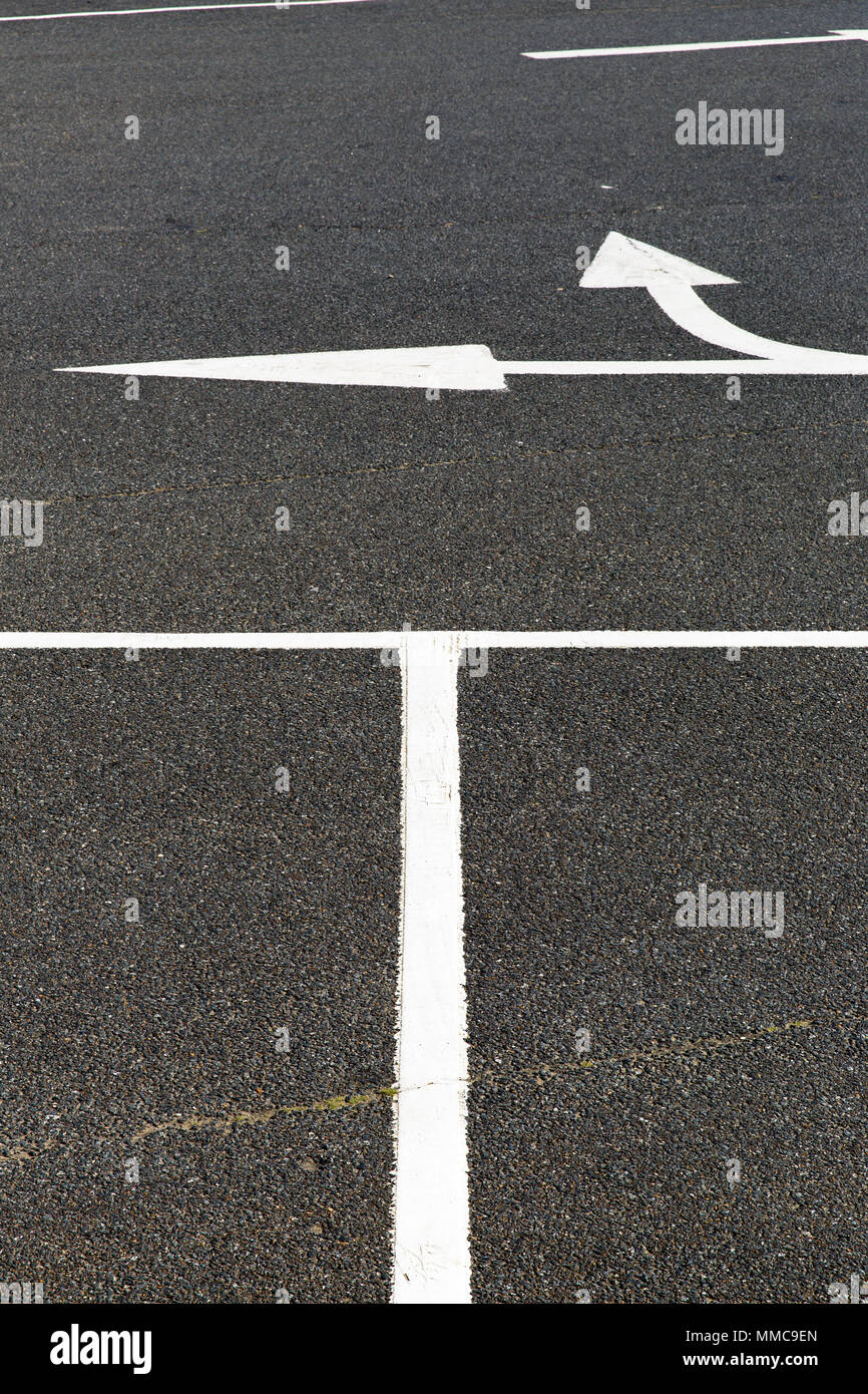 Una disposizione astratta per le linee bianche e le frecce sul black tarmac di un parcheggio auto Sandown Isola di White, UK. Foto Stock