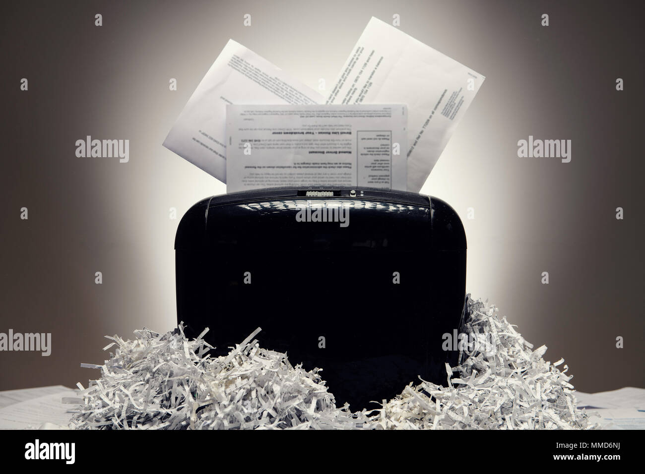 Office shredder e documenti personali essendo sminuzzato, con pile di carta tagliuzzata. Foto Stock