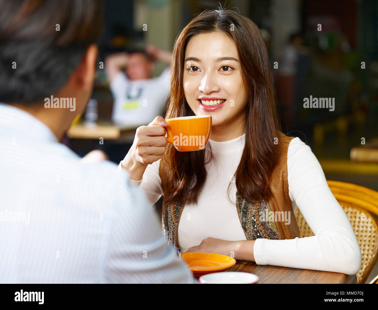 Giovani asiatici gli amanti della coppia seduta a tavola in chat di parlare faccia a faccia in un coffee shop. Foto Stock