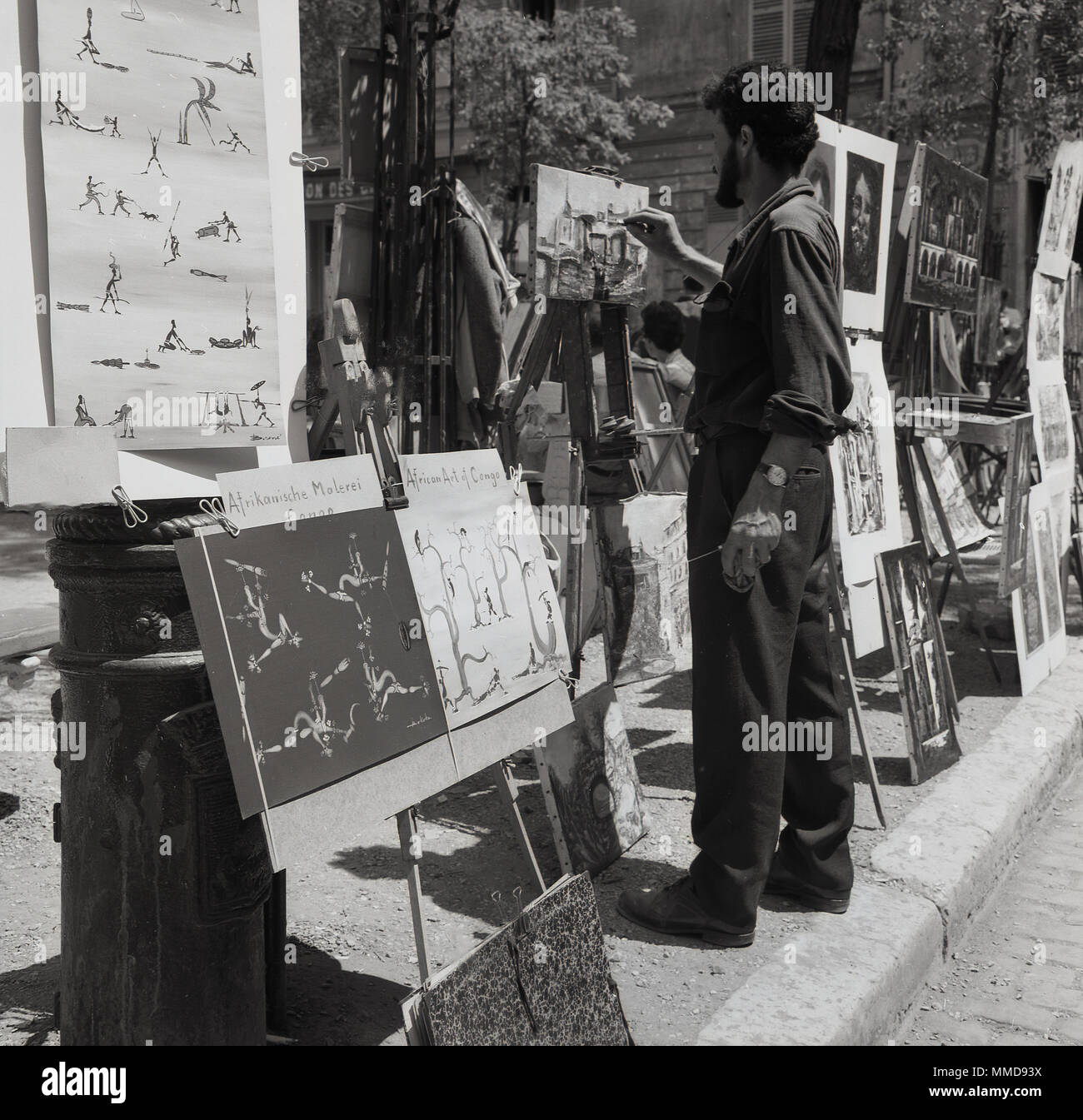 Degli anni Cinquanta, foto storiche di un maschio di artista di strada in una pittura su tela a La Place du Tertre a Montmartre, Paris, Francia, una zona famosa per i suoi artisti e storia artistica, Foto Stock