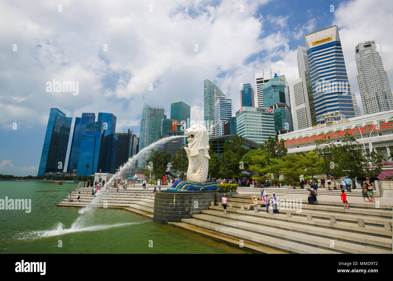 Il Merlion, mascotte non ufficiale di Singapore, a metà pesce e metà-Leone, a Marina Bay con la skyline di Singapore in background. Foto Stock