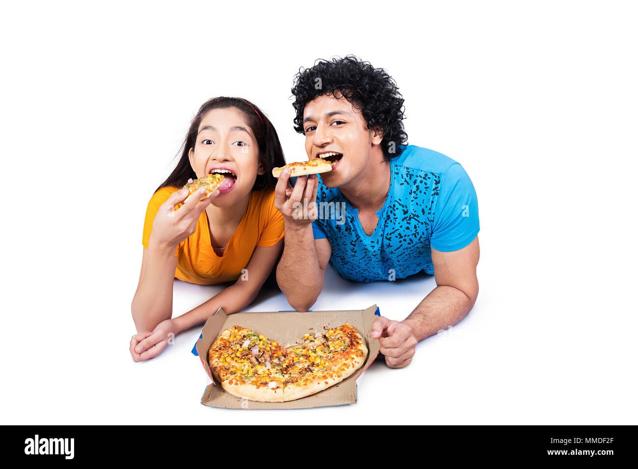 Due Coppia Giovane ragazzo e ragazza distesa piano mangiare Tasty-Pizza Foto Stock