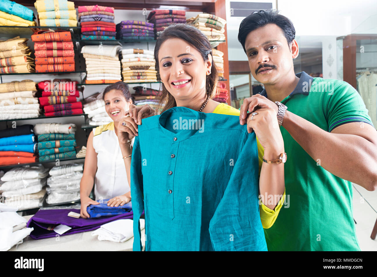 Tre persone, negoziante e un paio di clienti che acquistano Salwar-Kameez negozio di abbigliamento Foto Stock