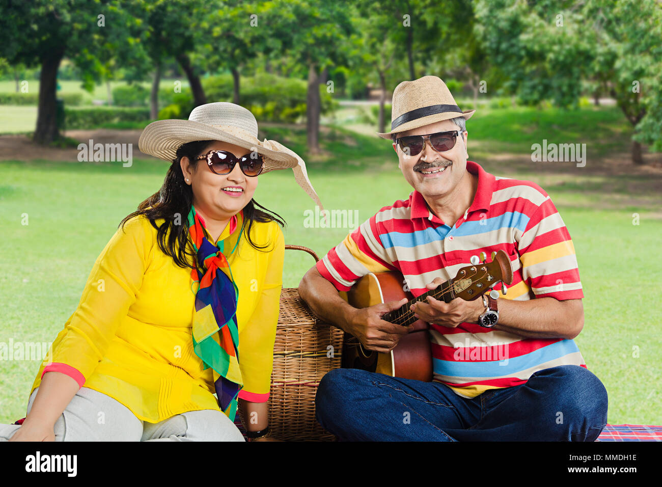 Due amanti Senior matura in amore con picnic in-park con la chitarra Foto Stock
