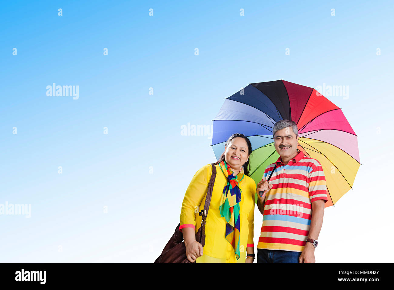 Felice coppia Senior insieme sotto l ombrello protezione del sole godendo all'aperto Foto Stock