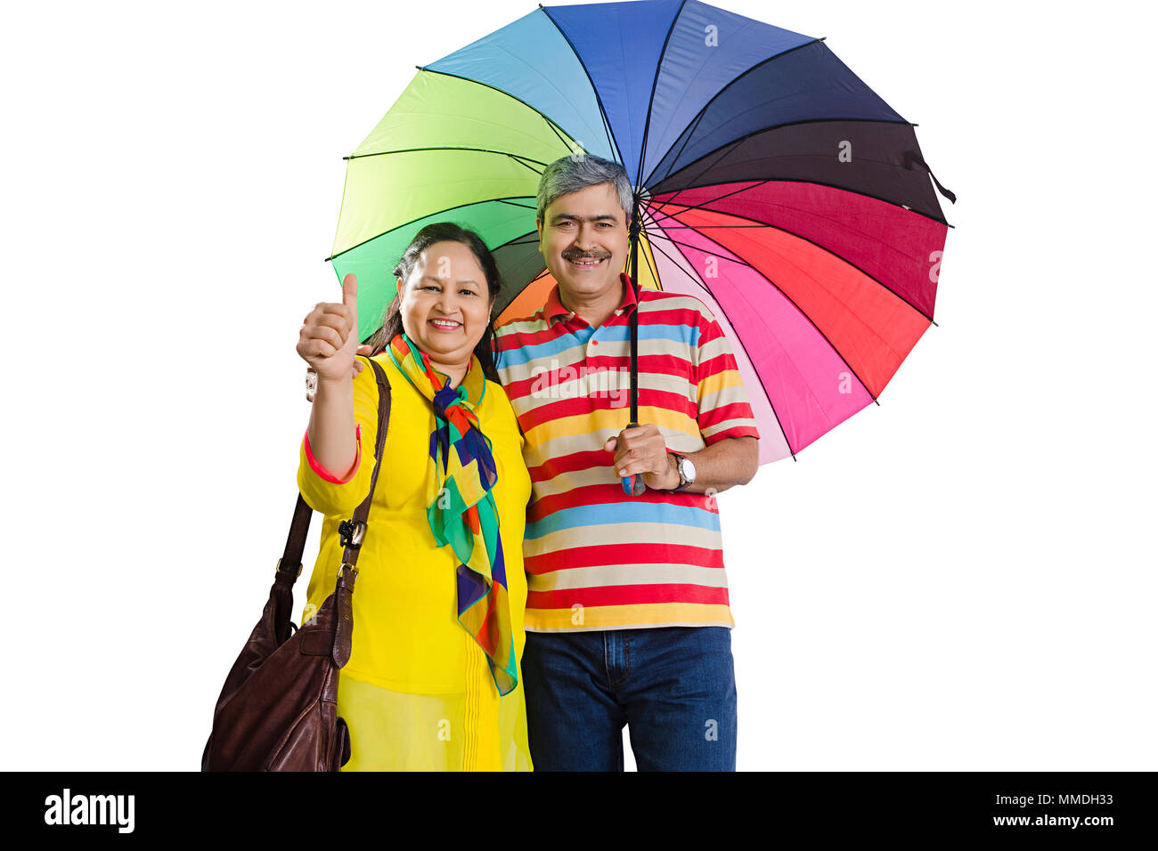 Felice coppia Senior sotto ombrellone insieme mostra Thumbs up Good-Luck Foto Stock