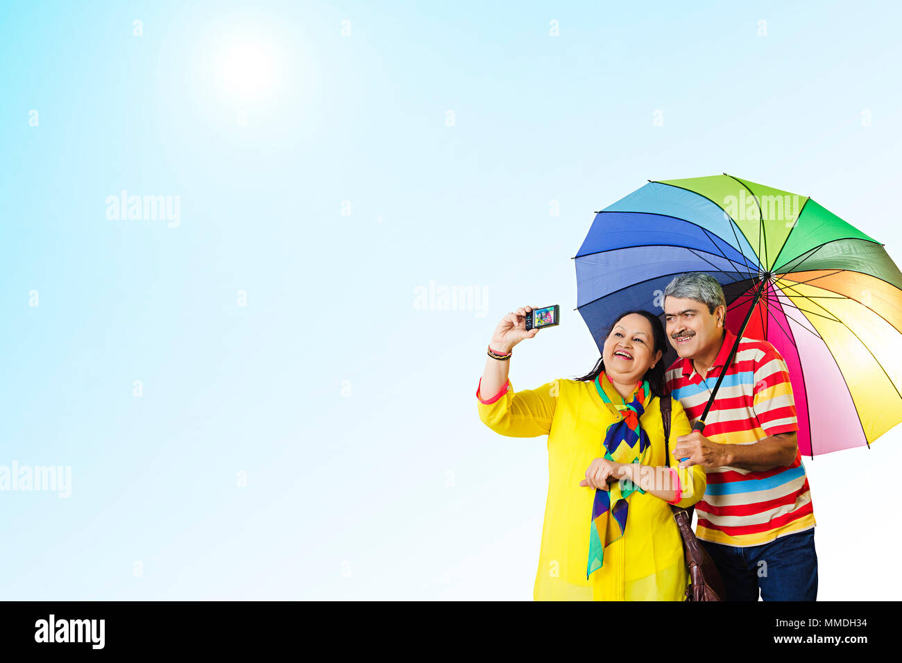 Felice coppia Senior sotto ombrellone tenendo Selife foto fotocamera all'aperto Foto Stock