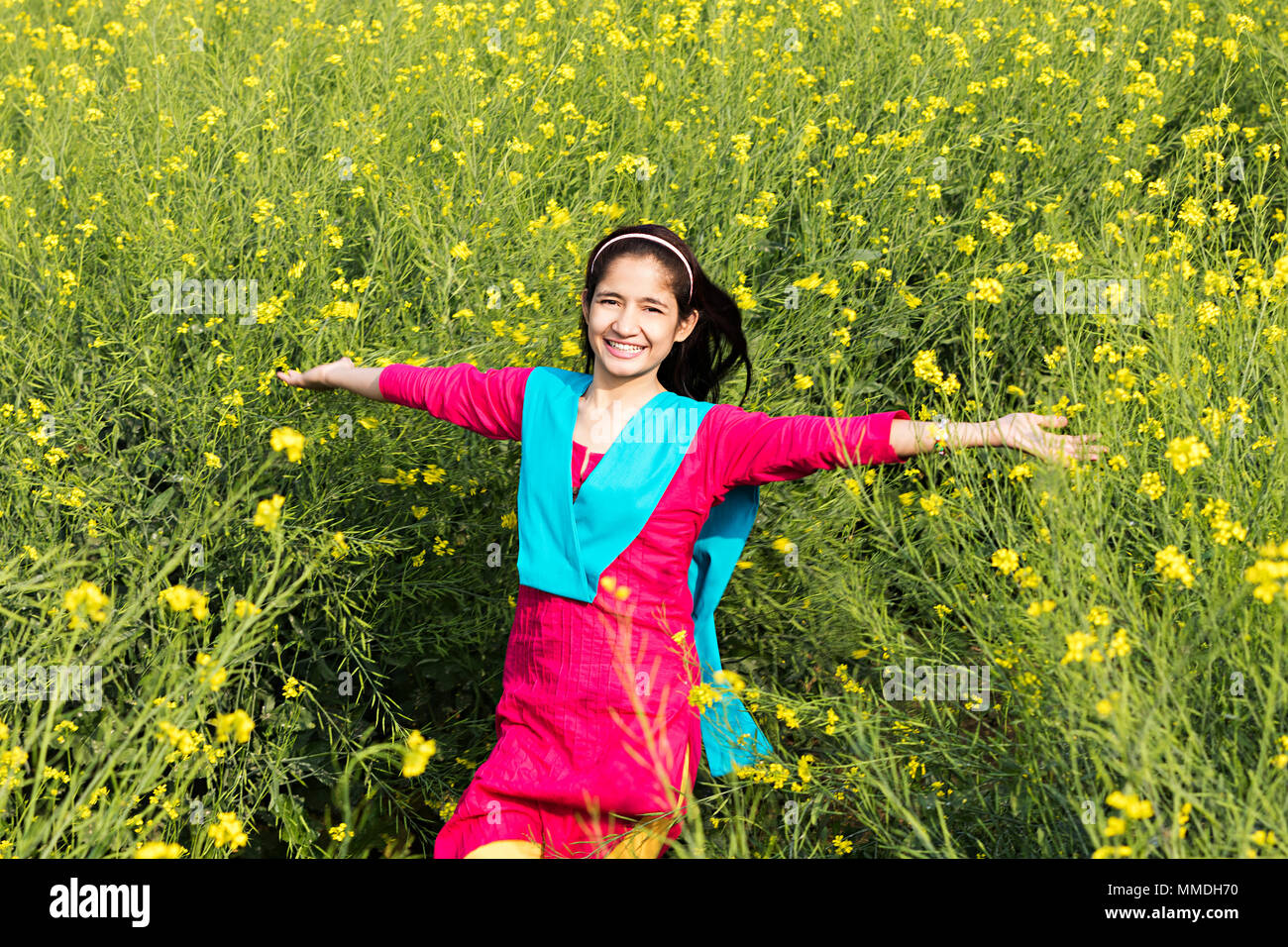 Felice rurale una ragazza adolescente campo Arms-Outstretched divertimento allegro Foto Stock