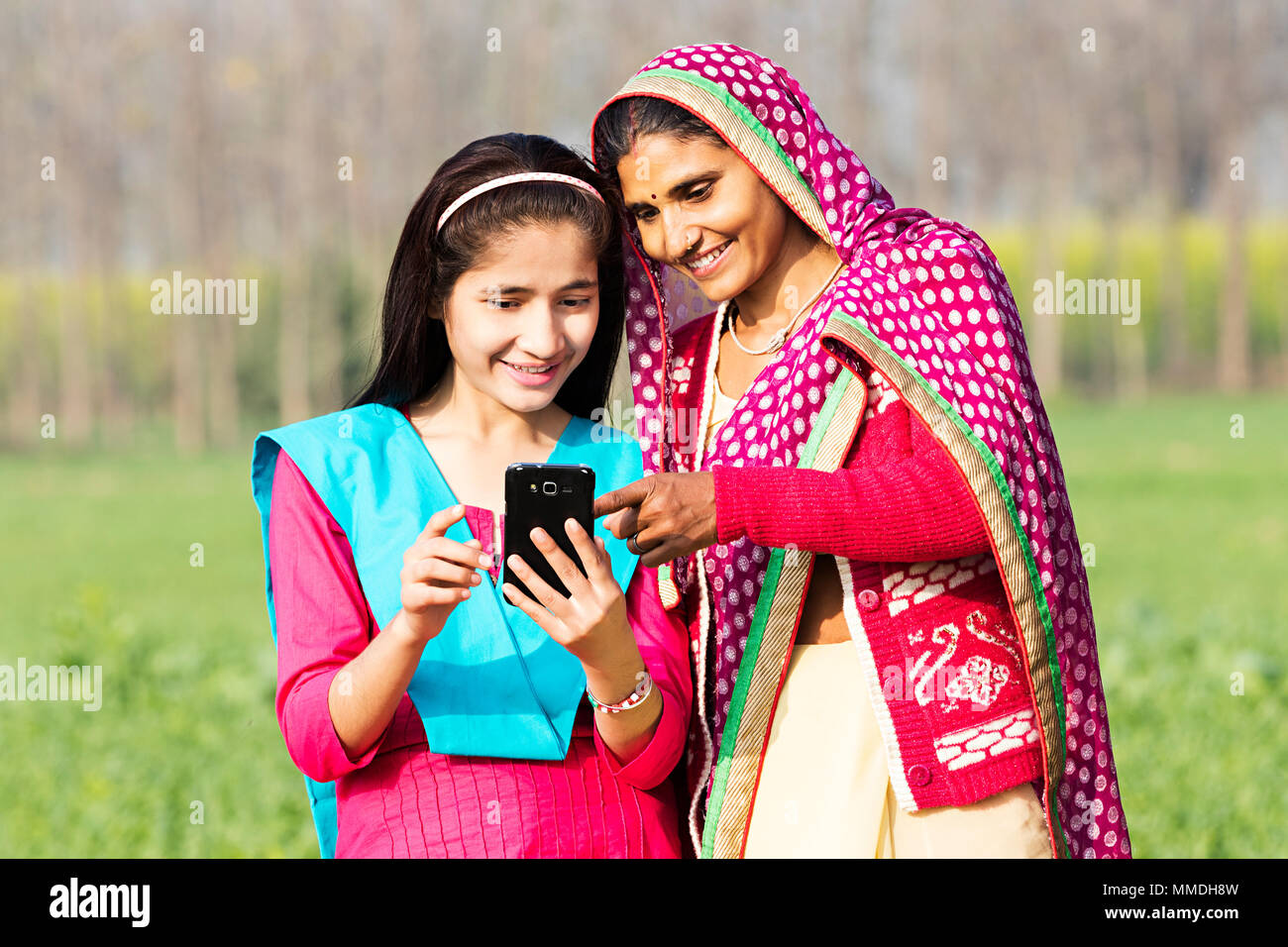 Rural madre e figlia Mobile-Phone di lettura schermo di puntamento del villaggio di fattoria Foto Stock