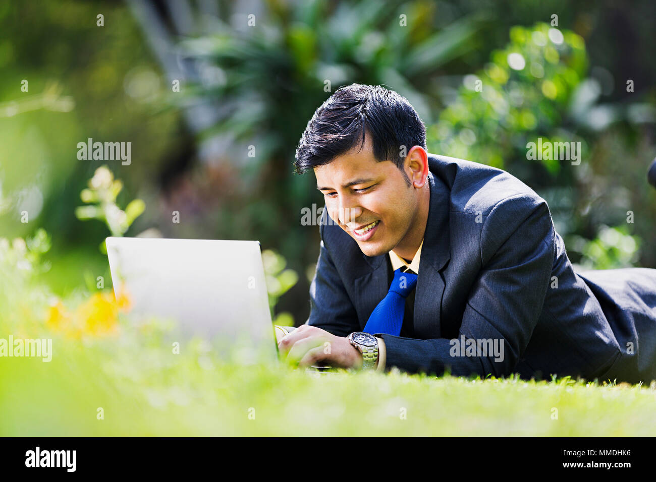 Un imprenditore dipendente erba giacente in appoggio utilizzando Laptop lavora in giardino Foto Stock