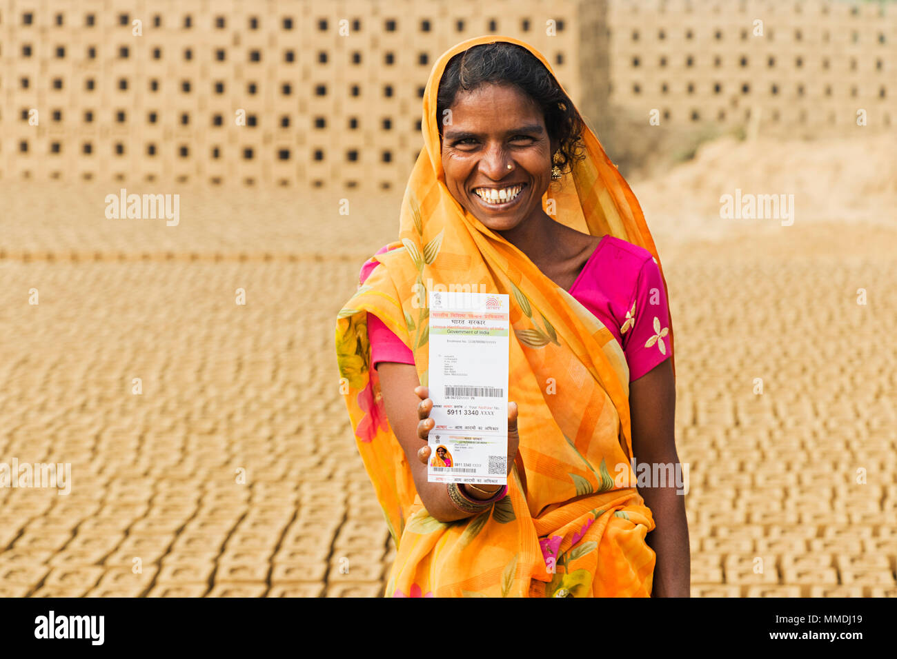 Una femmina di mattoni del lavoro in fabbrica che mostra Aadhaar-Card Governo - Industria In-Village Foto Stock