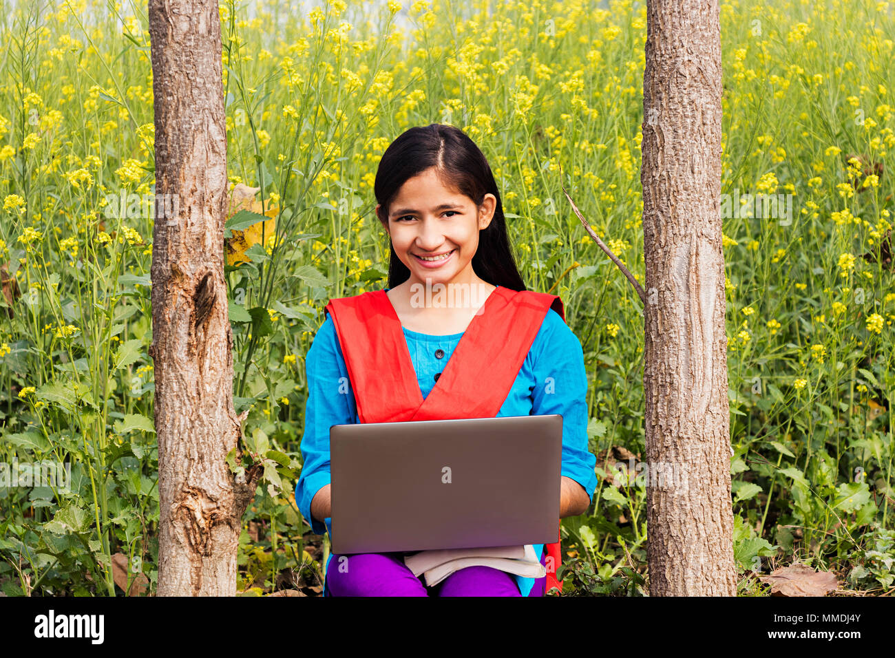 Abitante di villaggio rurale High-School una studentessa seduta fattoria di lavoro portatile E-Learning Foto Stock