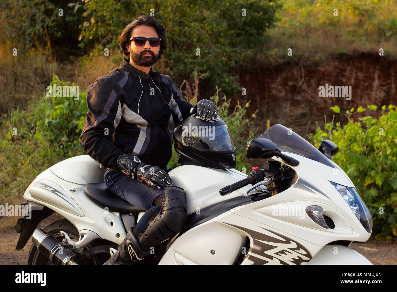 Giovane uomo in abito nero con un bianco potente moto Foto Stock