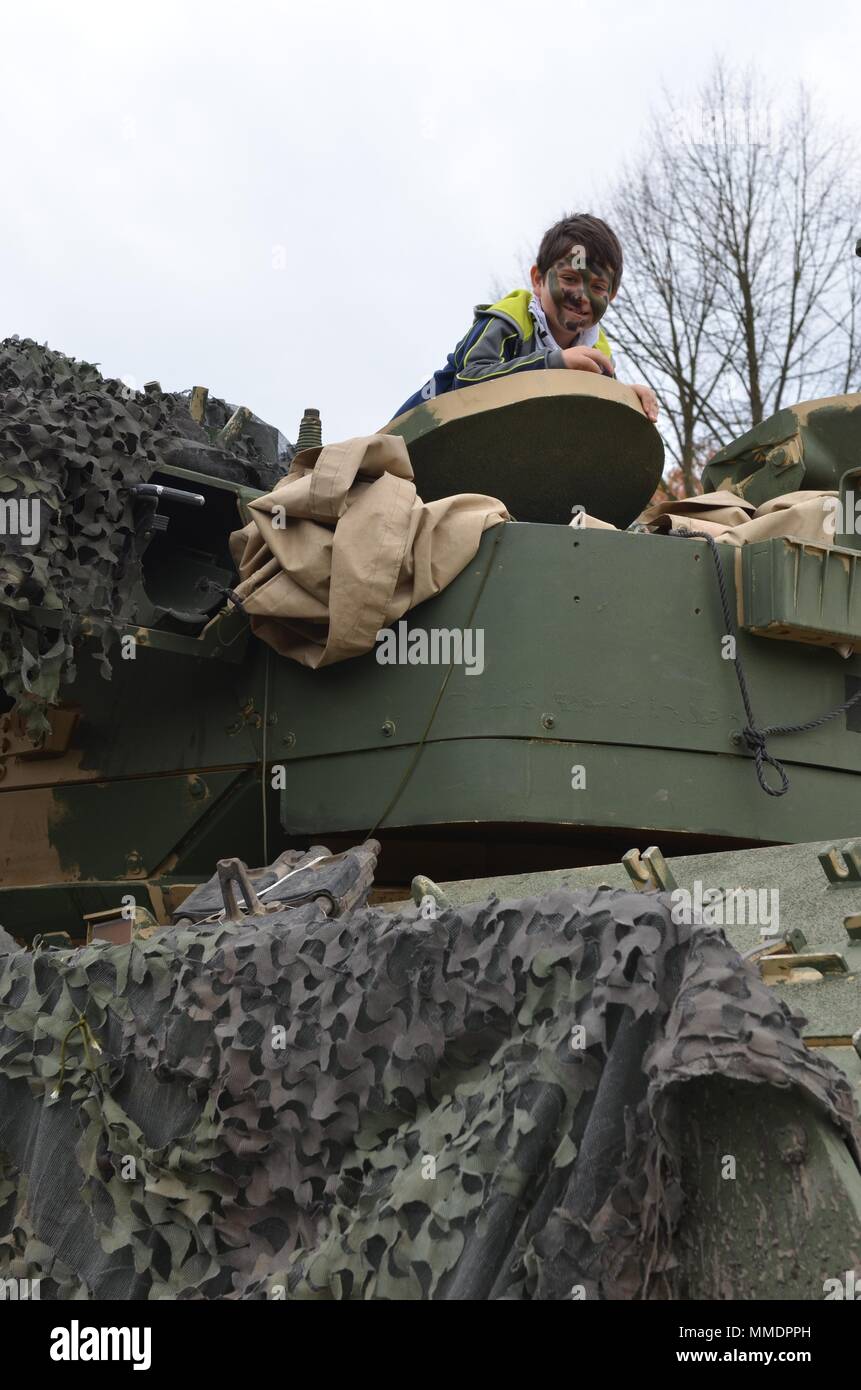 ZAGAN, Polonia - un giovane visitatore al museo di prigionieri nei campi di prigionia, Zagan, coetanei al di fuori della parte superiore di un M1 Abrams serbatoio durante il museo dell'evento speciale dotato di U.S. I soldati dell esercito dal 2° Brigata corazzate contro la squadra, 1° Divisione, Museo di prigionieri nei campi di prigionia, Zagan, Polonia, Ott. 21. I soldati di partecipare in un display di esercito di attrezzature di supporto relazioni polacco-americano, storia e educazione Stalag Luft III campo di prigionia e la II Guerra Mondiale, poiché l'unità era attiva in Europa durante quel tempo. Attrezzatura visualizzato nel caso sono un M113, Armored Trasporto di personale M1 AB Foto Stock