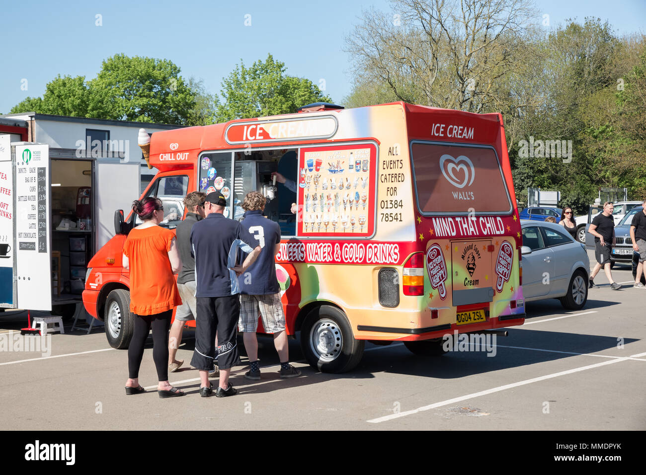 UK gelateria van con la gente che si accatera per gelato all'aperto sotto il sole estivo. Foto Stock