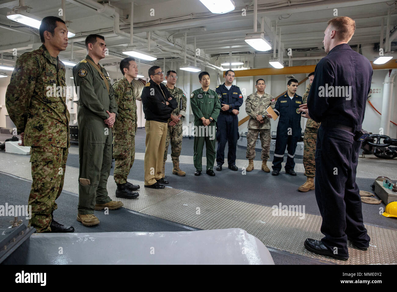 Stati Uniti Navy Petty Officer di terza classe Brandon Faleide, un compagno di boatswain assegnato alla USS Essex (LHD 2), descrive le caratteristiche della nave di ancoraggio per gli osservatori stranieri che partecipano in esercizio Alba Blitz, 24 ottobre, 2017. Opportunità di formazione come Alba Blitz offrire una possibilità per le forze degli Stati Uniti per aumentare l'interoperabilità con i paesi partner con i quali si può effettuare operazioni in futuro, real-crisi mondiale. (U.S. Marine Corps foto di Sgt. Aprile il Prezzo di L.) Foto Stock