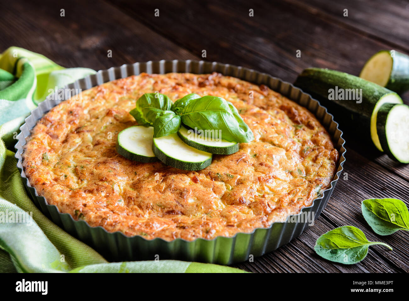 Tortino di zucchine con pancetta e formaggio, cipolla, prezzemolo e basilico Foto Stock