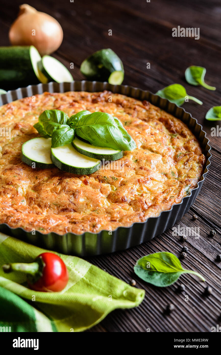 Tortino di zucchine con pancetta e formaggio, cipolla, prezzemolo e basilico Foto Stock