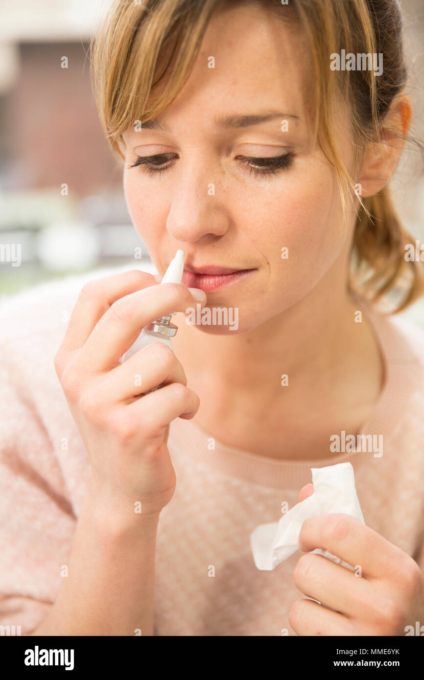 Donna che utilizza spray nasale Foto Stock