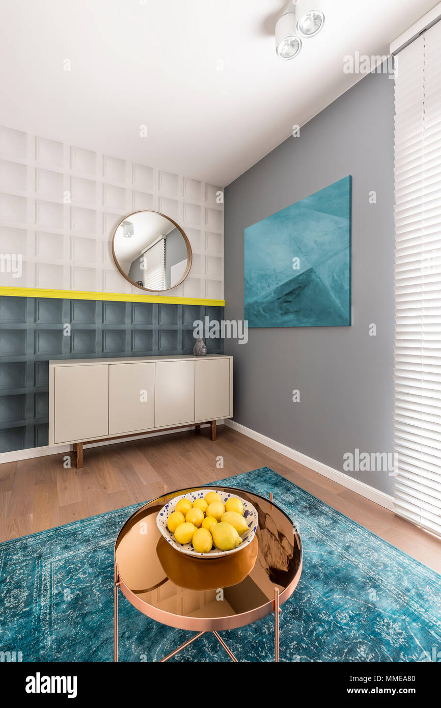 In bianco e nero di stampaggio quadrato giallo con dettaglio sulla parete  in moderno colorato soggiorno con credenza, pittura, rame tavolino da caffè  e turchese r Foto stock - Alamy