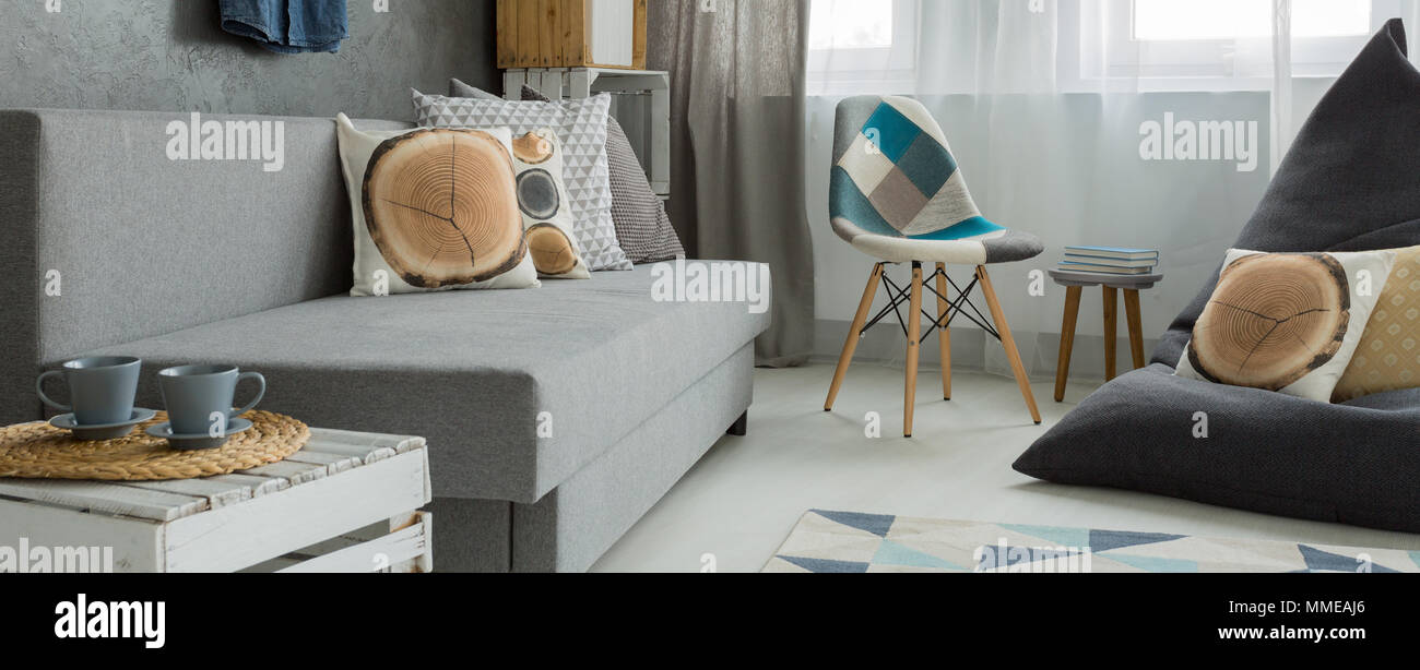 Salotto accogliente angolo di un soggiorno disposti in grigio e bianco con l'uso di modelli naturali e materiali Foto Stock
