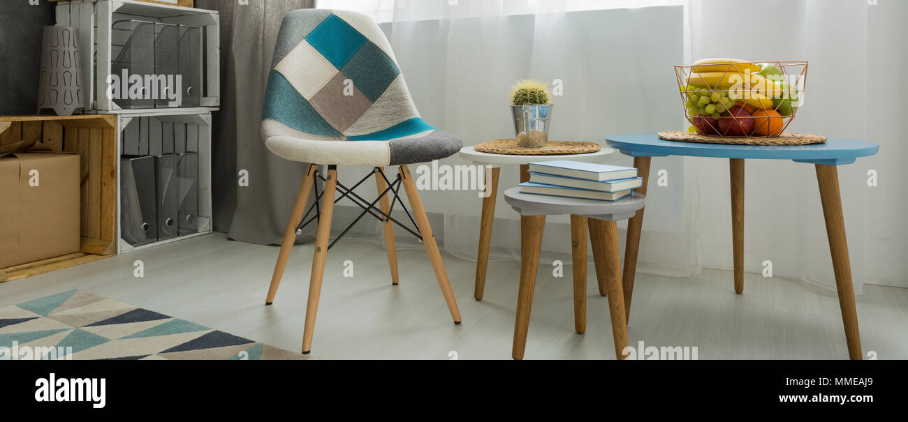 Close-up di un tavolino e una sedia patchwork in un luminoso soggiorno  moderno Foto stock - Alamy