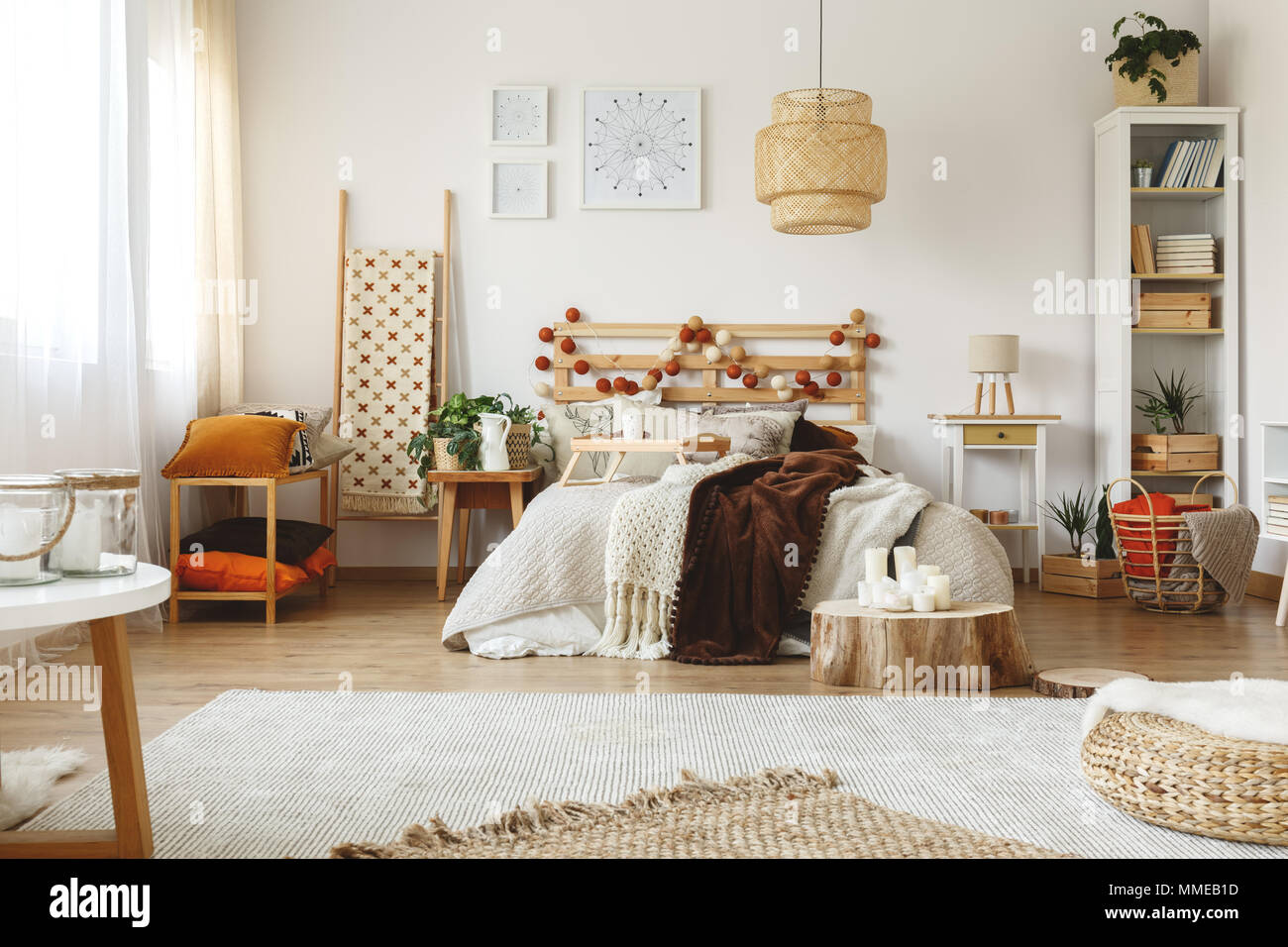 Spaziosa e luminosa camera da letto accogliente con fresche piante e decorazioni in legno Foto Stock