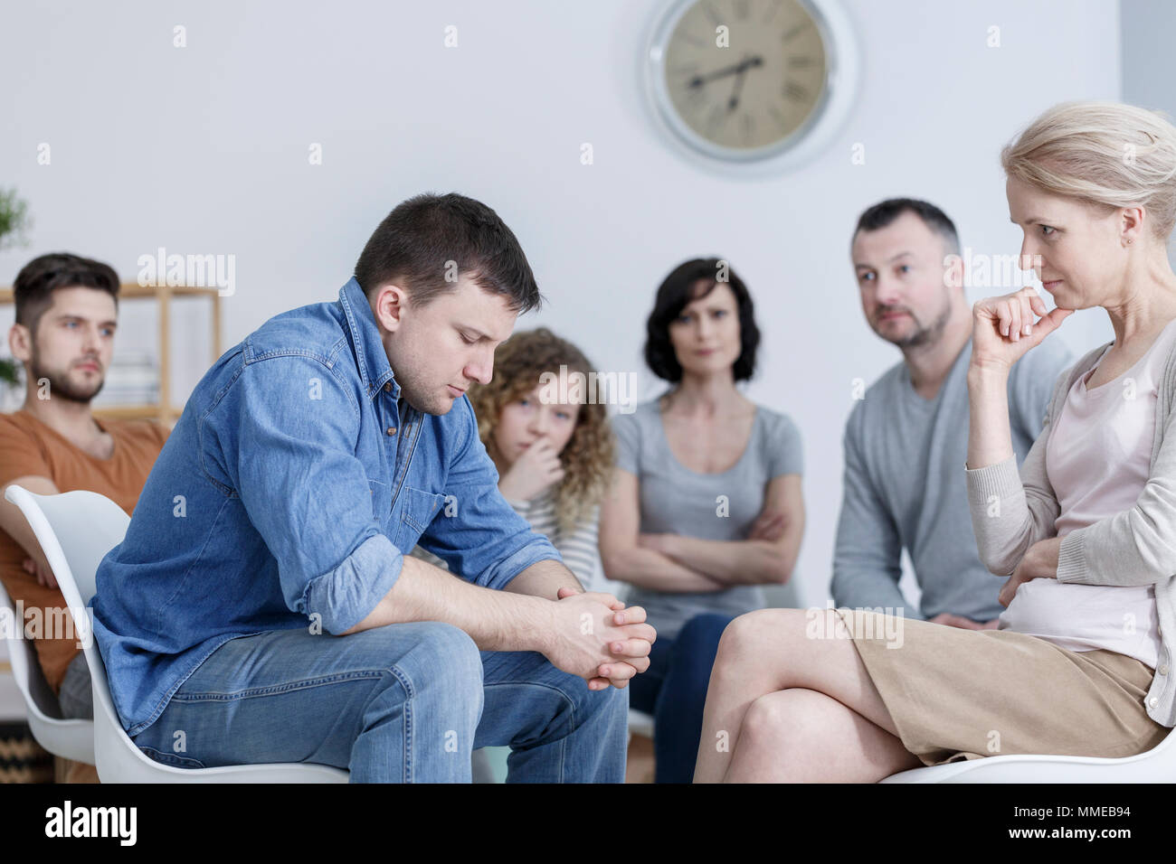 Uomo che fa la confessione di supporto durante la riunione di gruppo Foto Stock